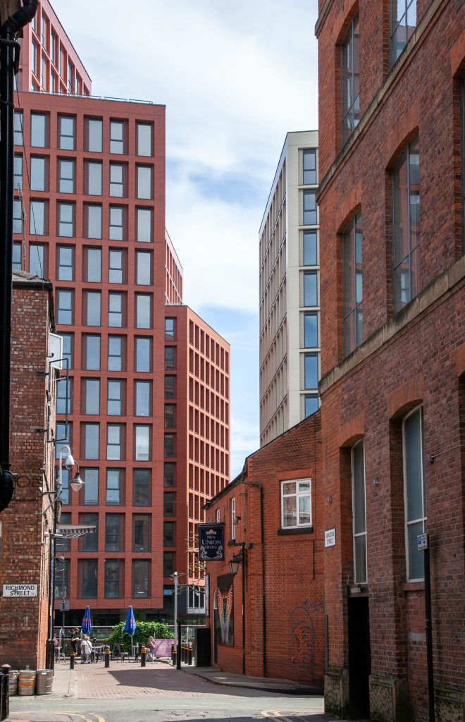 Red and beige high-rise apartments in city regeneration zone