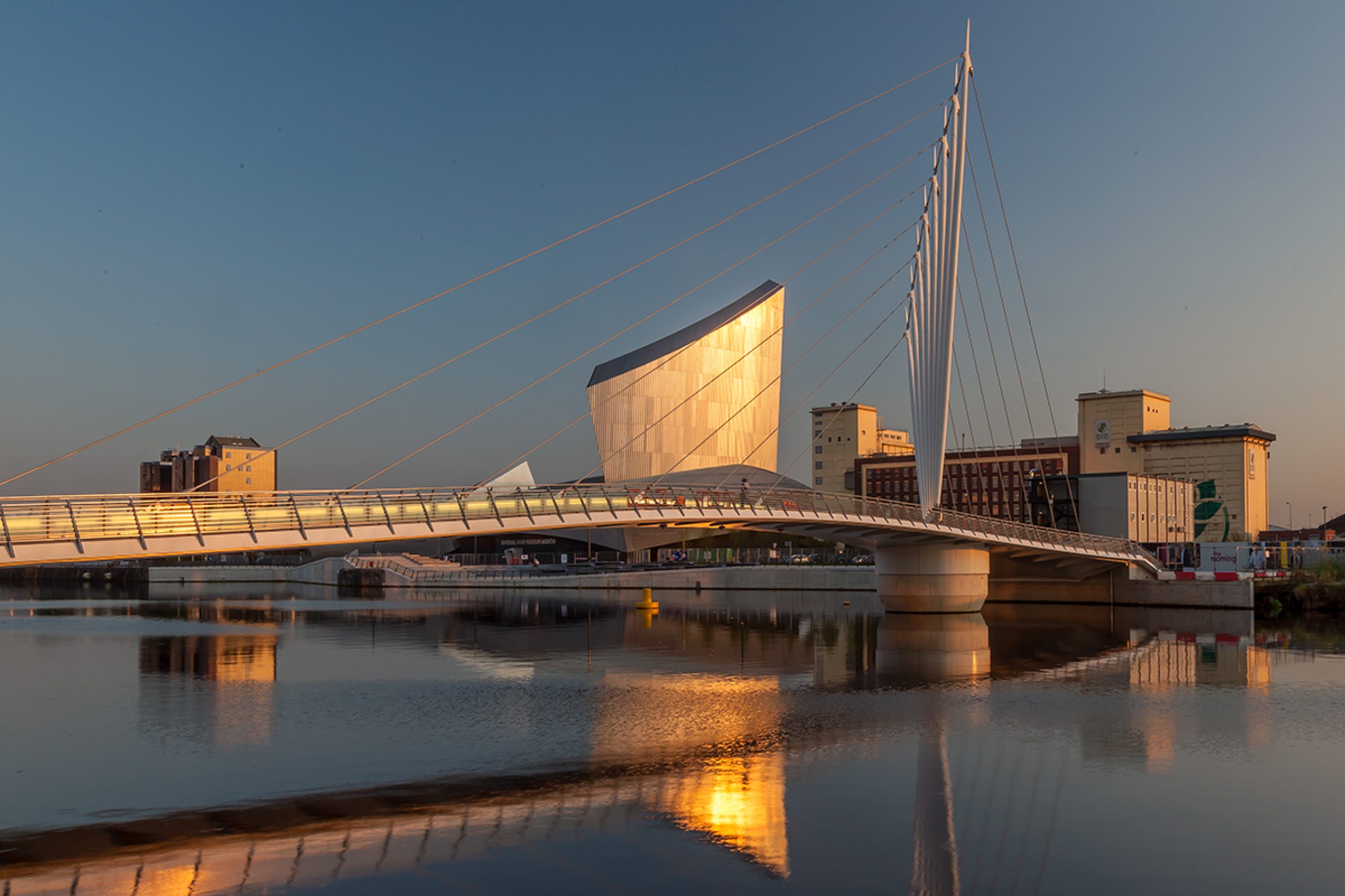 Imperial War Museum and Salford Quays footbridge at golden hour