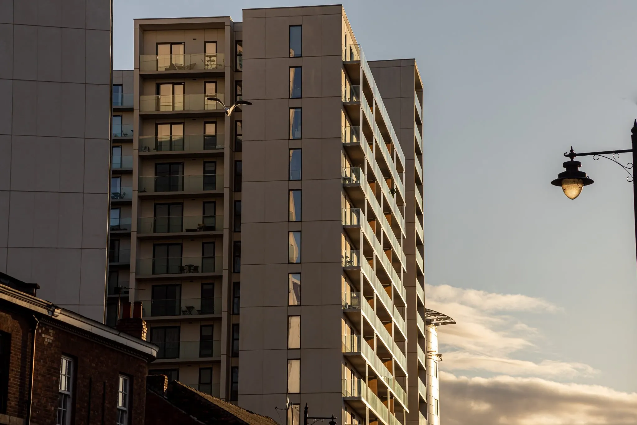 Residential high-rise with glass balconies at golden hour
