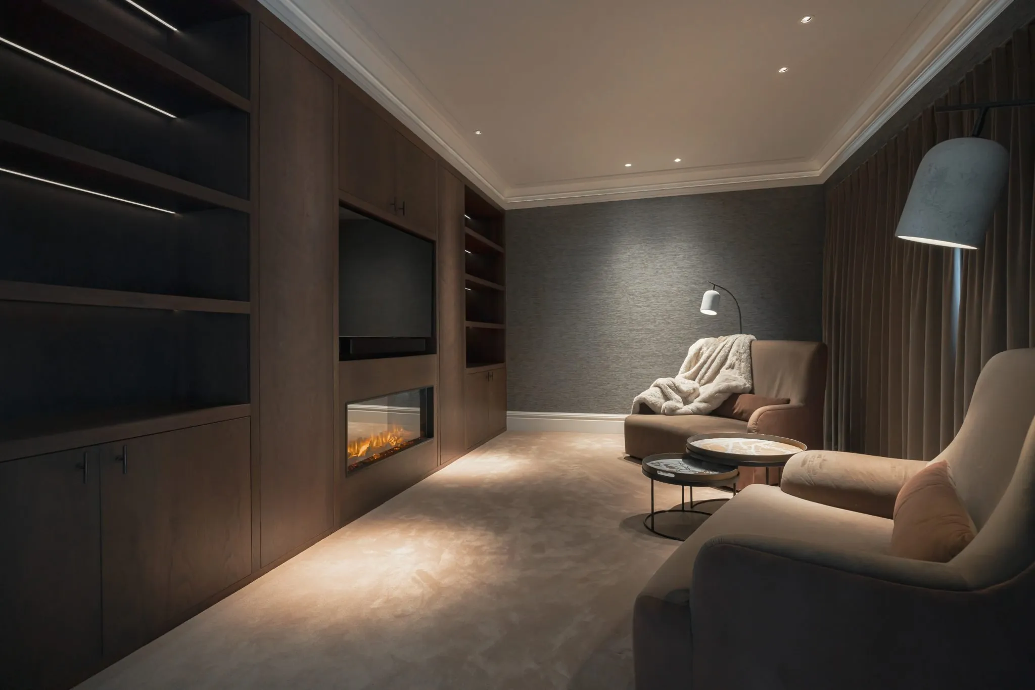 Modern home cinema room with built-in fireplace and recessed lighting